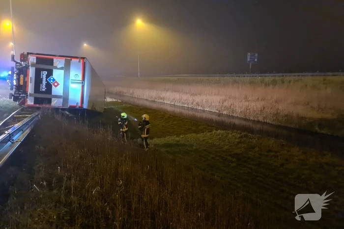 Vrachtwagen belandt op zijn kant in middenberm
