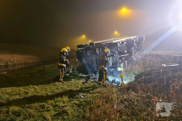 Vrachtwagen belandt op zijn kant in middenberm
