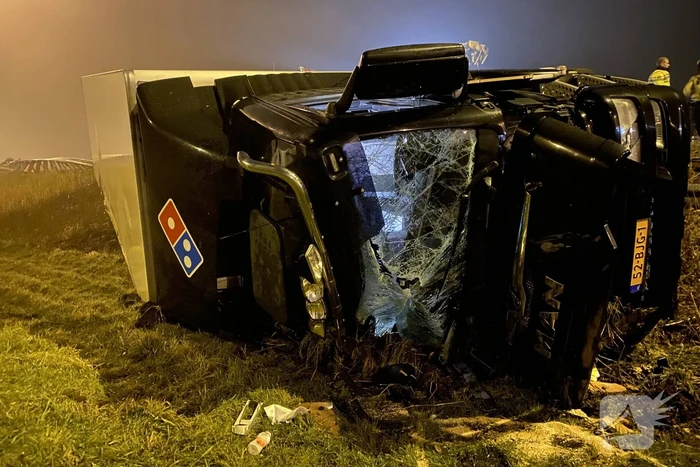 Vrachtwagen belandt op zijn kant in middenberm