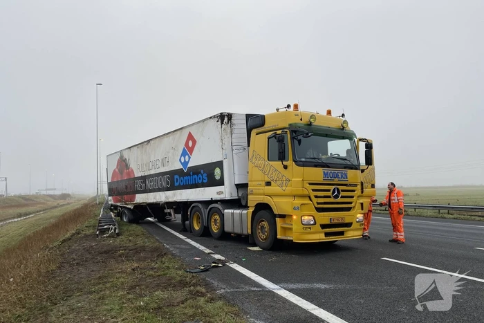 Vrachtwagen belandt op zijn kant in middenberm