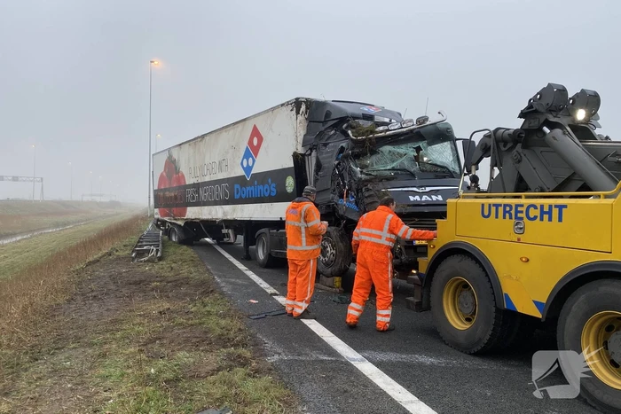 Vrachtwagen belandt op zijn kant in middenberm