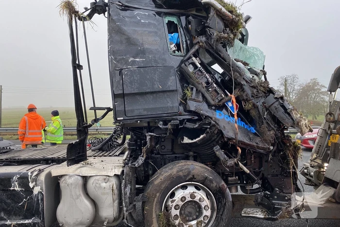 Vrachtwagen belandt op zijn kant in middenberm
