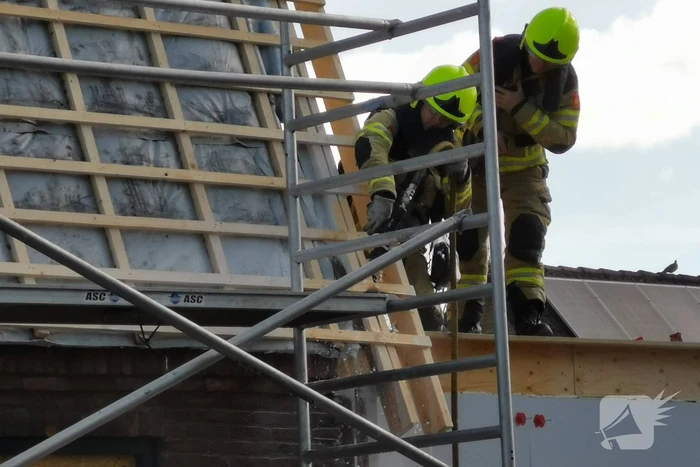 Brandweer blust brandende dakbedekking