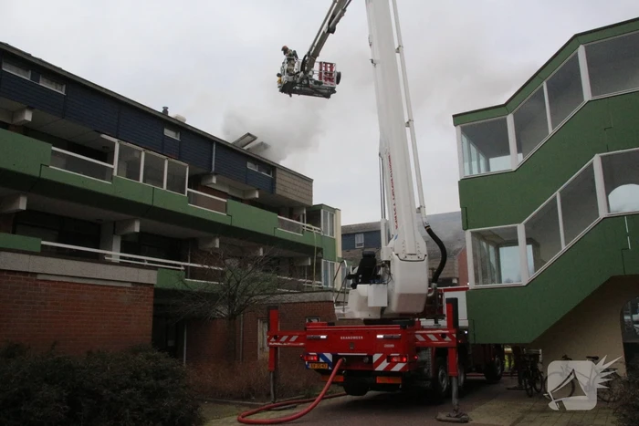 Brandweer blust brandend dak