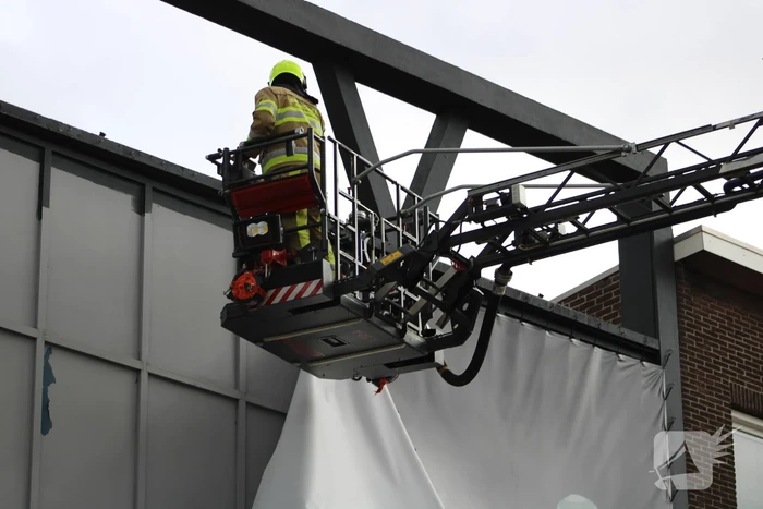 Reclamedoek Zonnestudio losgewaaid