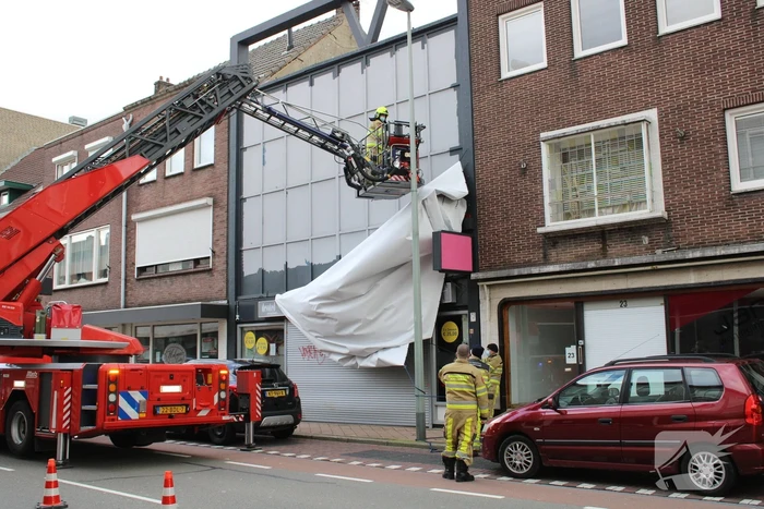 Reclamedoek Zonnestudio losgewaaid