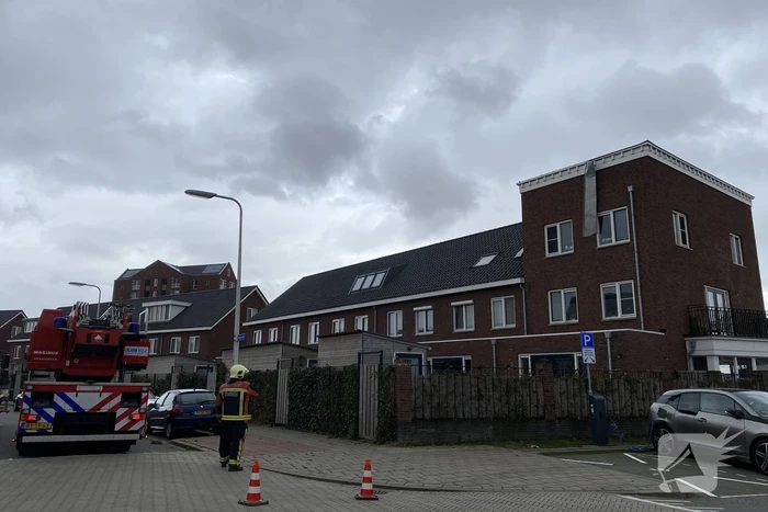 Brandweer haalt losgewaaide platen van dak