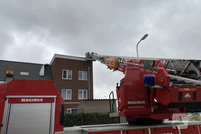 Brandweer haalt losgewaaide platen van dak