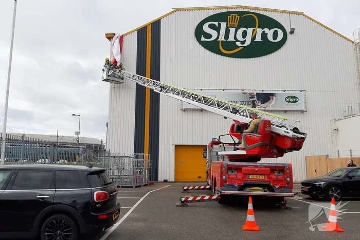 Brandweer verwijdert loshangend doek