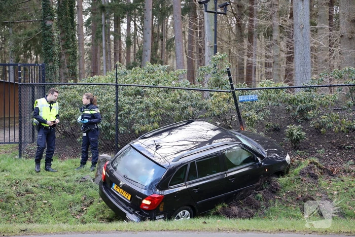Auto eindigt aan overkant van de weg in hekwerk