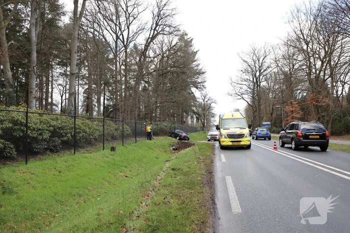 Auto eindigt aan overkant van de weg in hekwerk