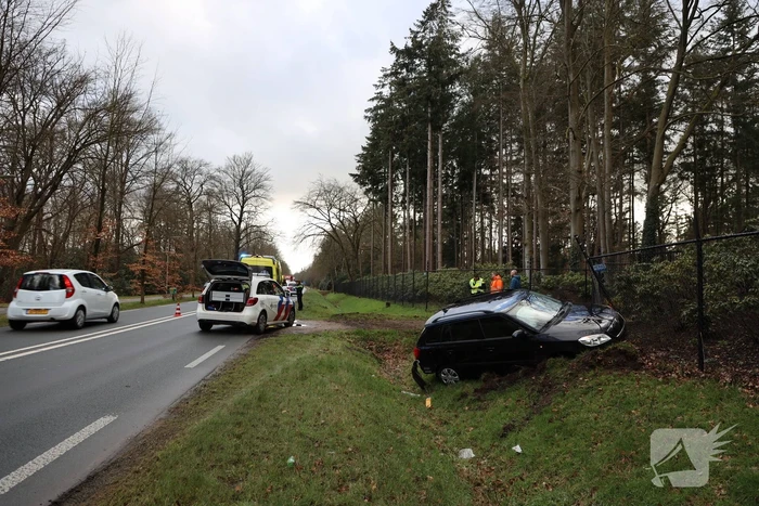 Auto eindigt aan overkant van de weg in hekwerk
