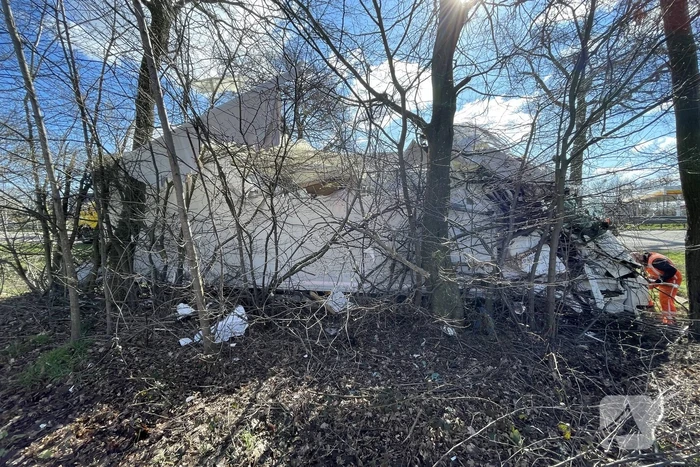 Vrachtwagen belandt in berm tegen boom