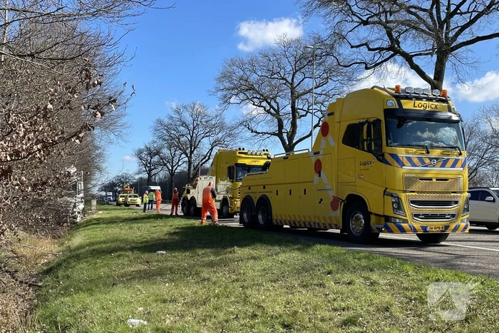 Vrachtwagen belandt in berm tegen boom