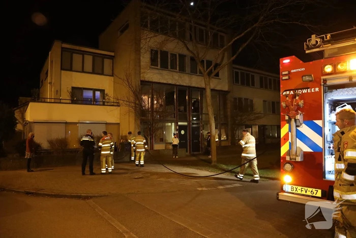 Brandweer blust brandende papiercontainer