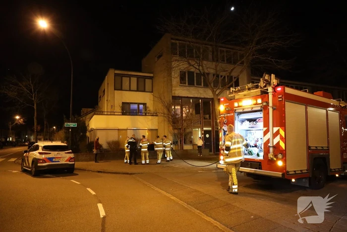 Brandweer blust brandende papiercontainer