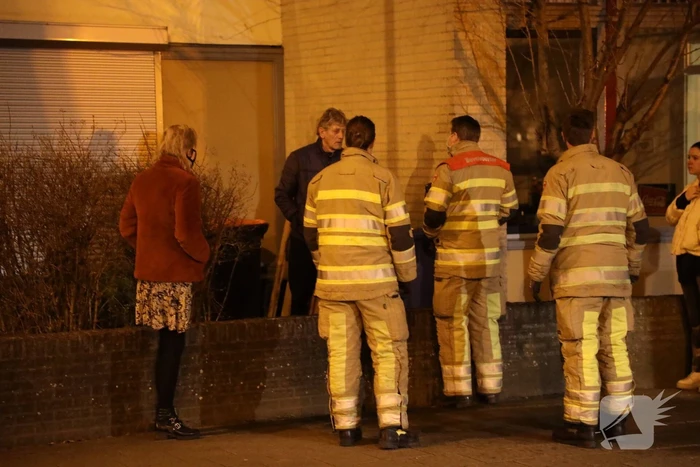 Brandweer blust brandende papiercontainer