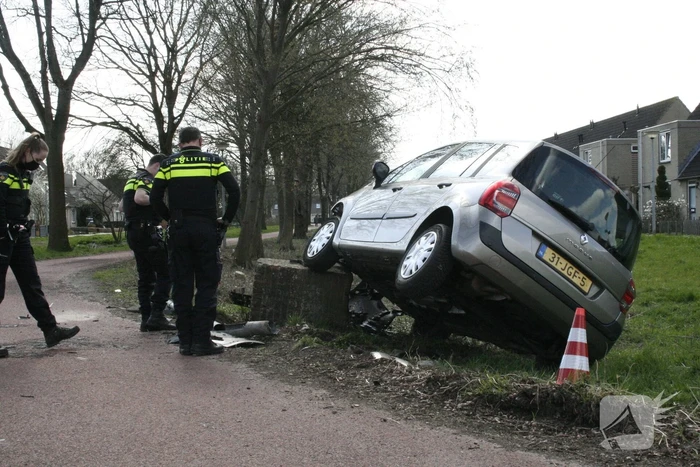 Auto botst op betonblok met lantaarnpaal