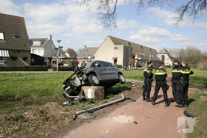Auto botst op betonblok met lantaarnpaal