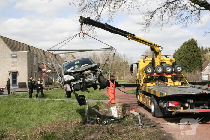 Auto botst op betonblok met lantaarnpaal