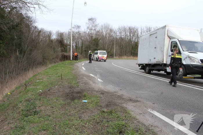 Bakwagen valt op zijkant in bocht