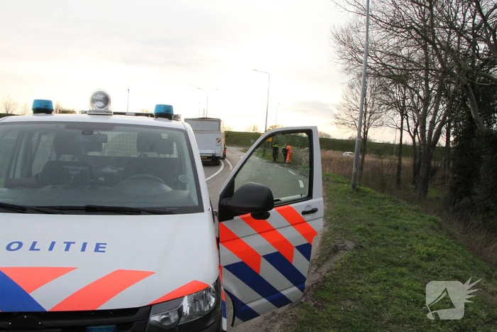 Bakwagen valt op zijkant in bocht
