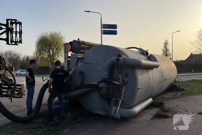 Giertank met mest gekanteld op rotonde
