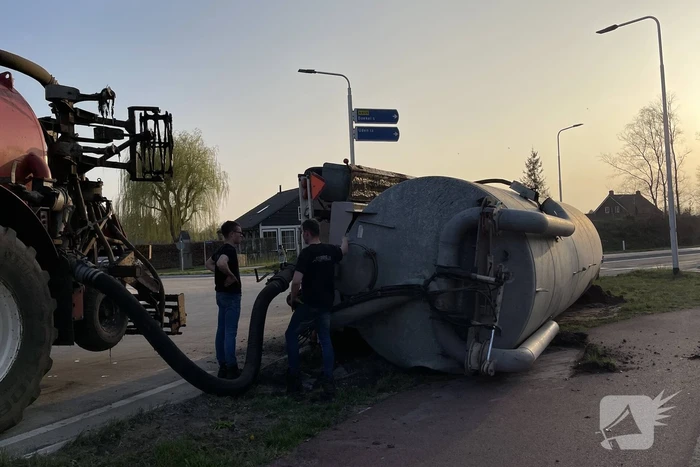 Giertank met mest gekanteld op rotonde