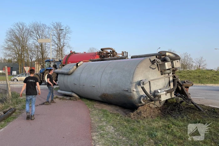 Giertank met mest gekanteld op rotonde