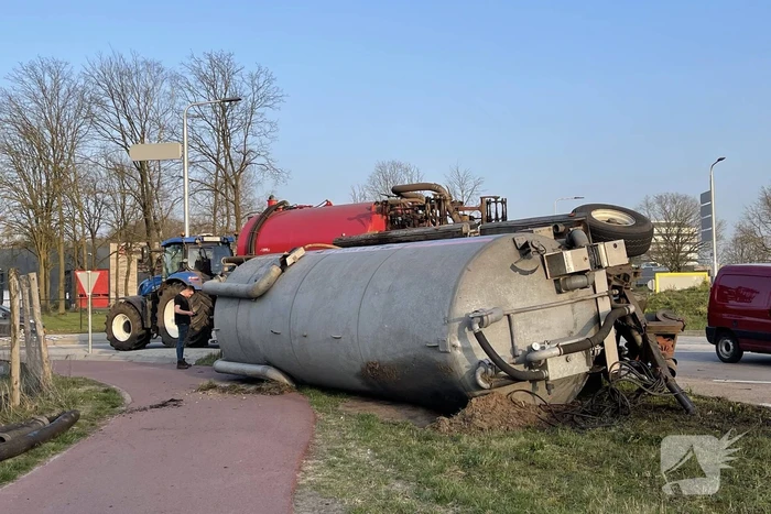Giertank met mest gekanteld op rotonde