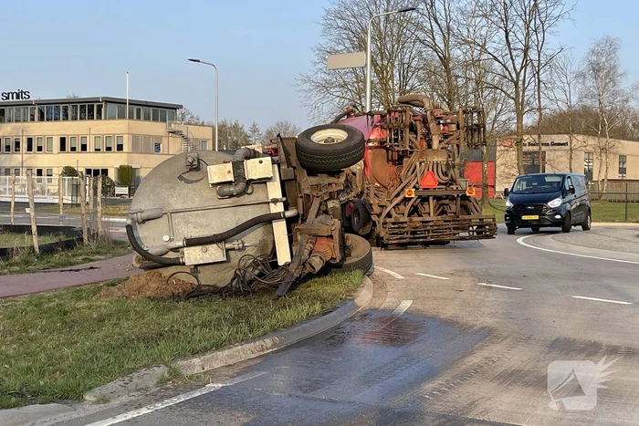 Giertank met mest gekanteld op rotonde