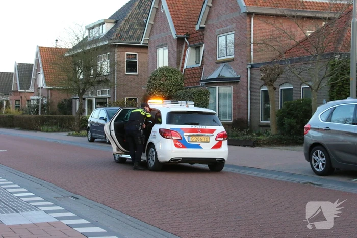 Busje op zijn kant na botsing met boom