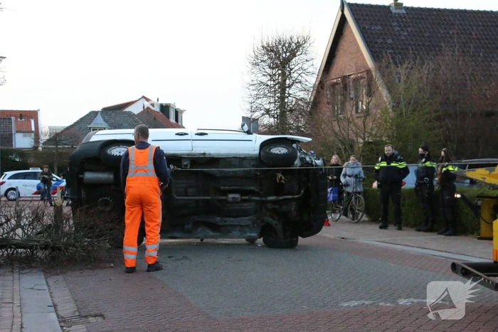 Busje op zijn kant na botsing met boom