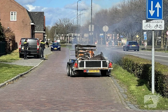 Brandweer blust brandende aanhanger
