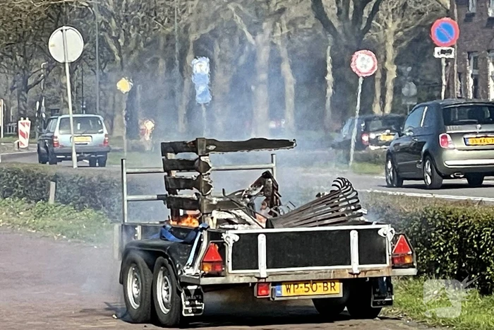 Brandweer blust brandende aanhanger