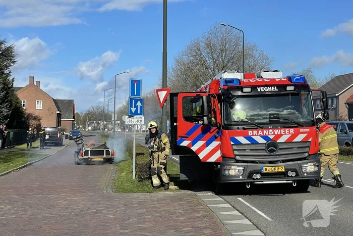 Brandweer blust brandende aanhanger