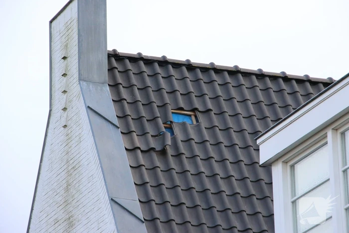 Dakpannen waaien van woning