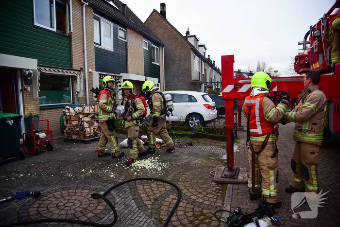 Brandweer blust stukken hout door brand in schoorsteen