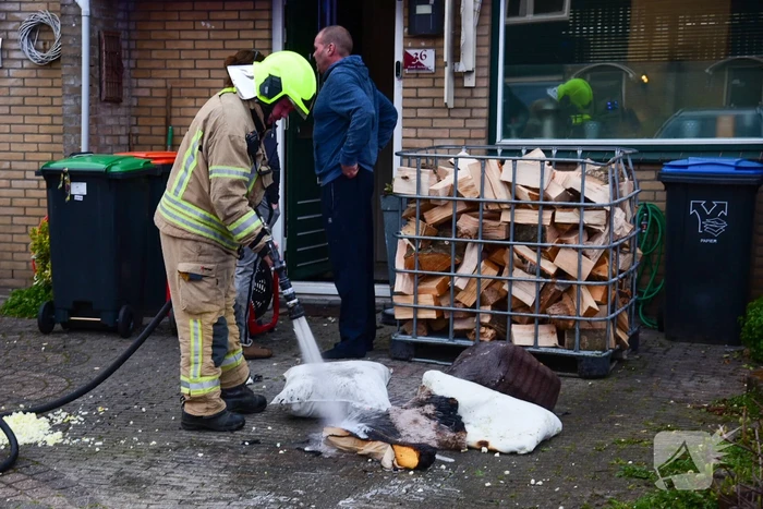 Brandweer blust stukken hout door brand in schoorsteen