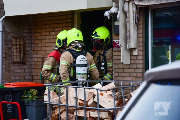 Brandweer blust stukken hout door brand in schoorsteen