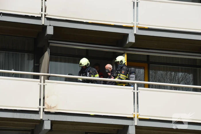 Brandweer blust brandende wasmand