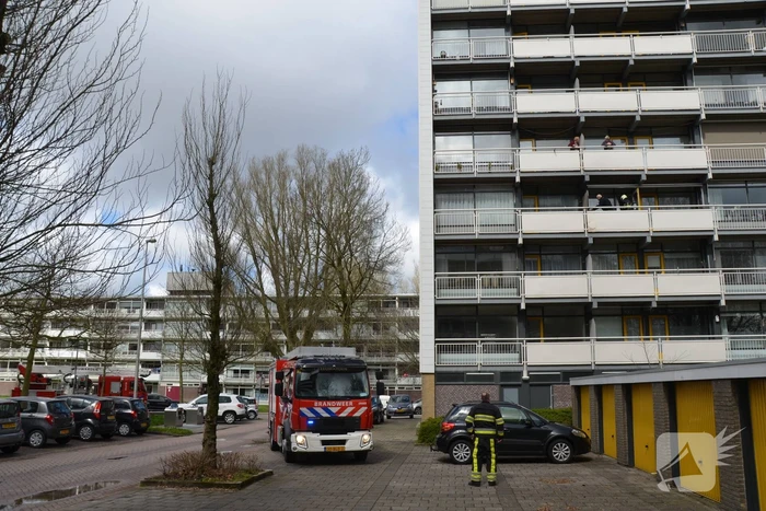 Brandweer blust brandende wasmand
