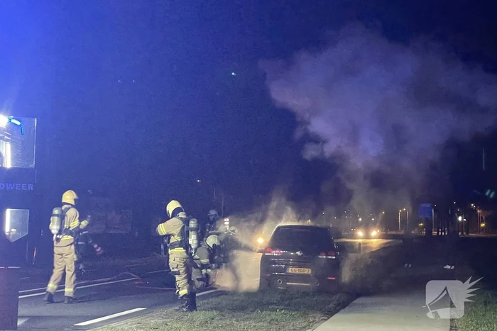Brandweer blust brandende personenauto