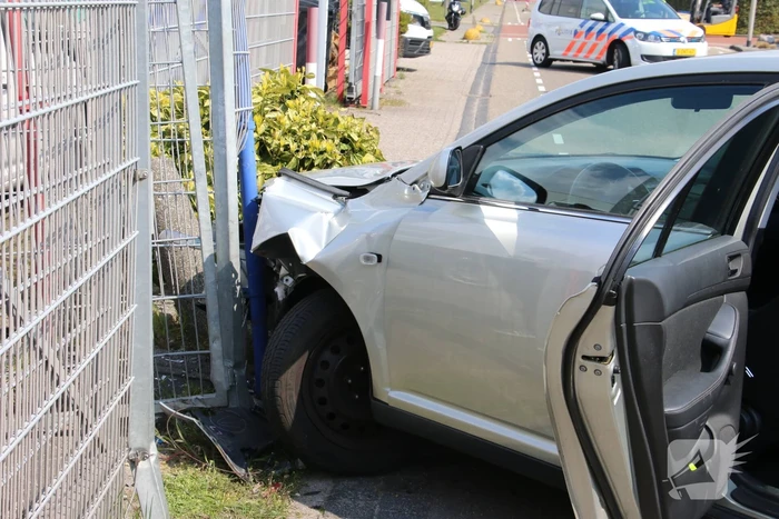 Auto knalt op hekwerk bedrijfspand