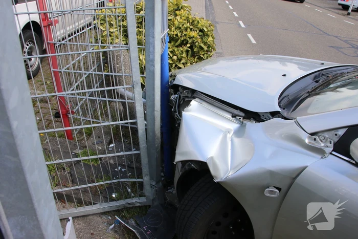 Auto knalt op hekwerk bedrijfspand