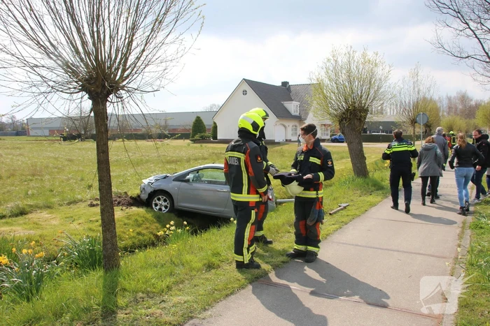 Auto schiet rechtdoor over rotonde en belandt bovenop sloot