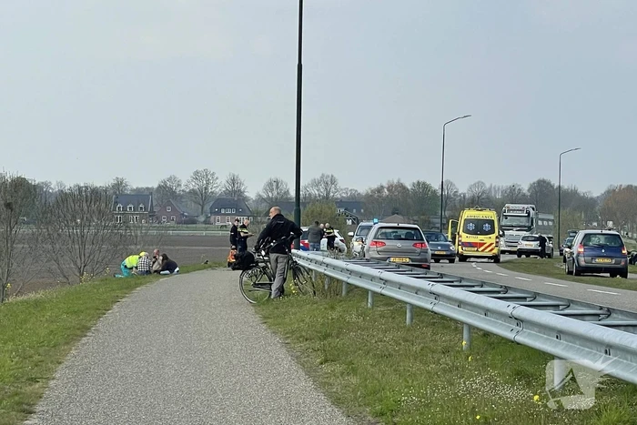 Auto glijdt van dijk af na botsing en vliegt in brand