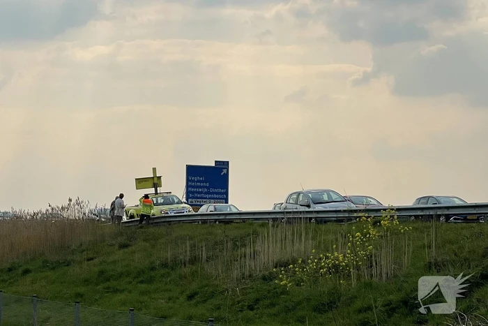 Auto glijdt van dijk af na botsing en vliegt in brand