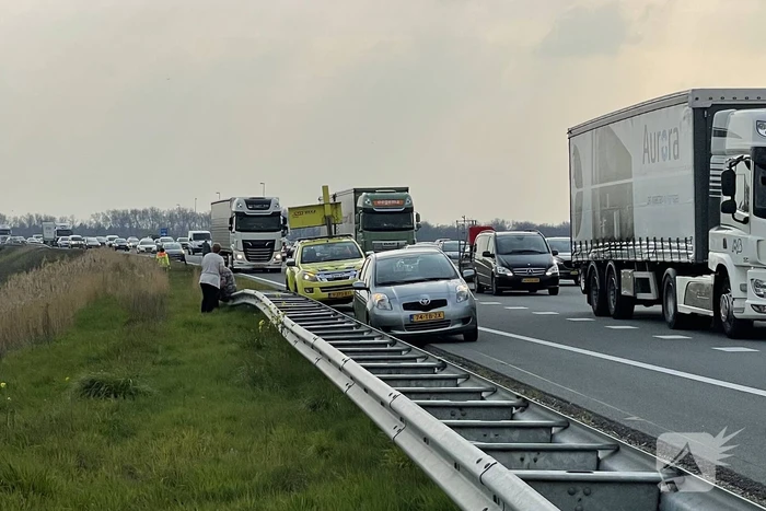 Auto glijdt van dijk af na botsing en vliegt in brand