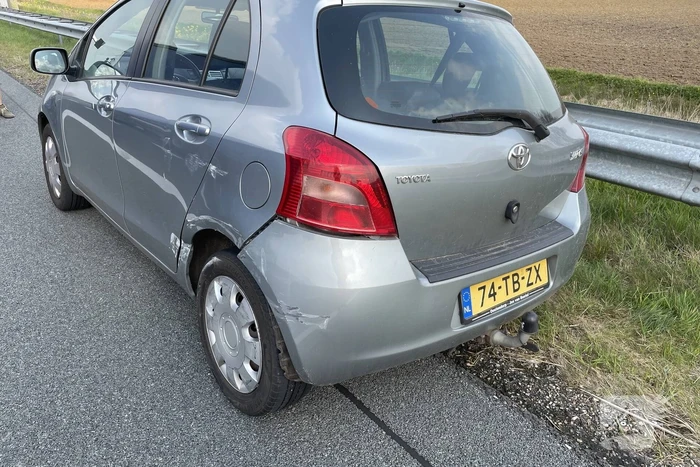Auto glijdt van dijk af na botsing en vliegt in brand